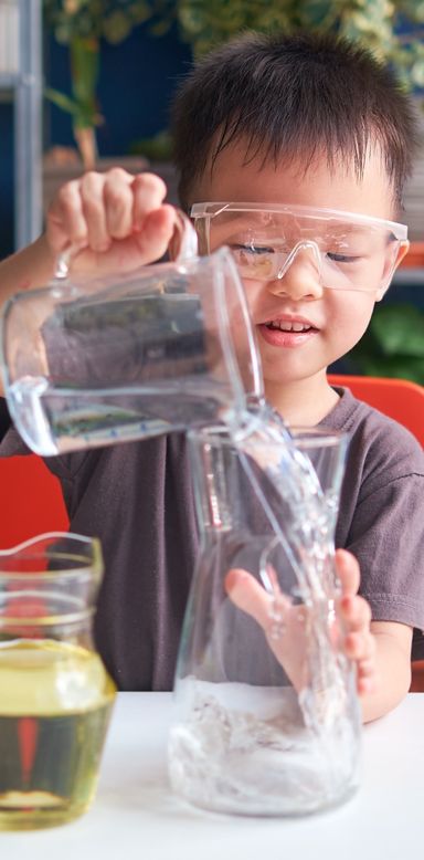 Enfant verse de l'eau dans une vase