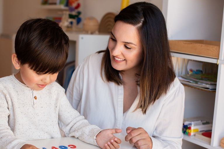 Two boys reading and writing, working together