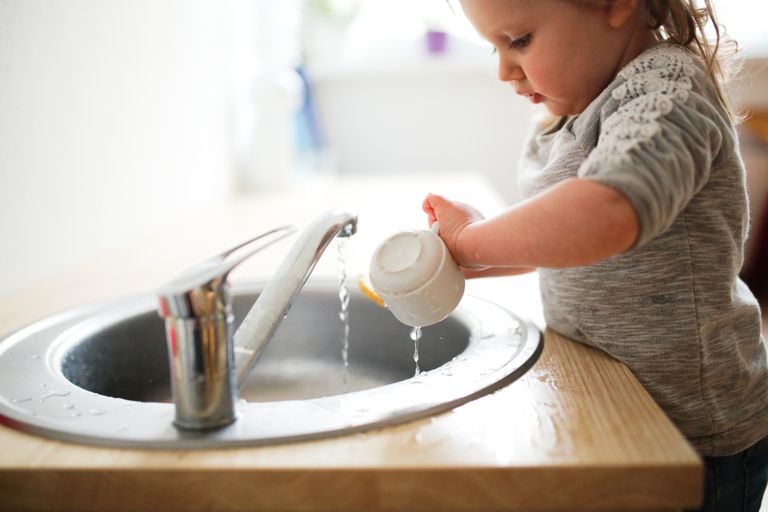 Enfant manipulant de petits objets, travaillant sur de la motricité fine
