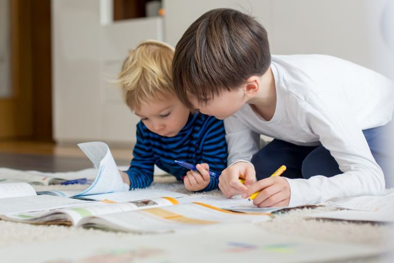 Two boys reading and writing, working together
