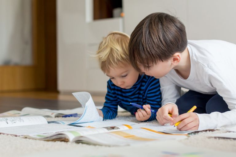 Deux garçons lisant et écrivant, travaillant ensemble